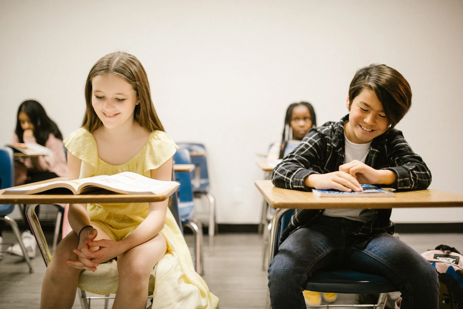 Two students reading and smiling in class