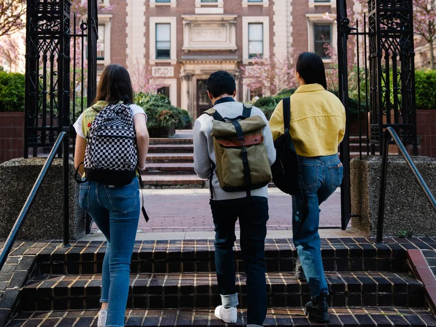 学生背着书包走向校园建筑