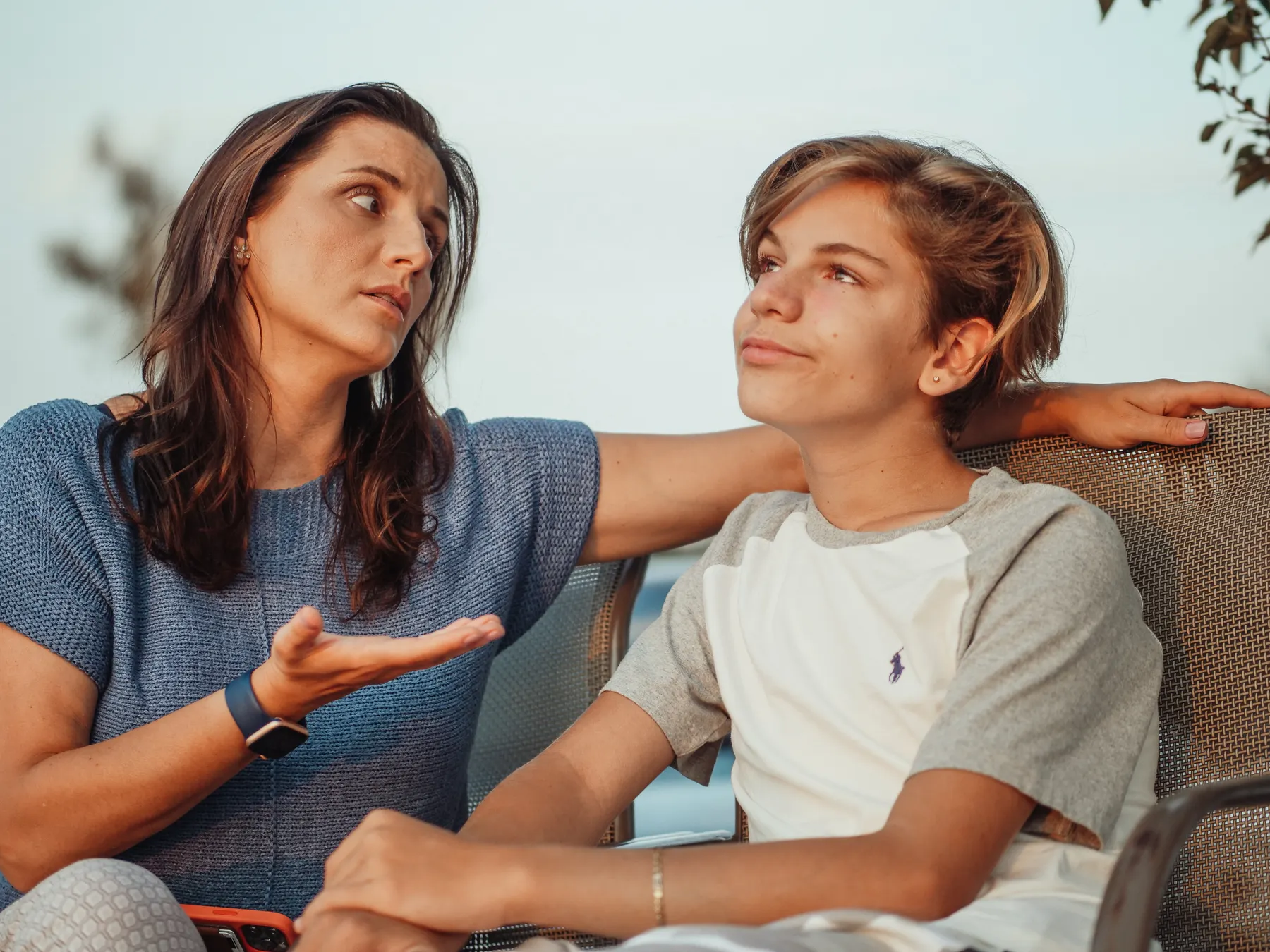 A parent and teenager talking outdoors