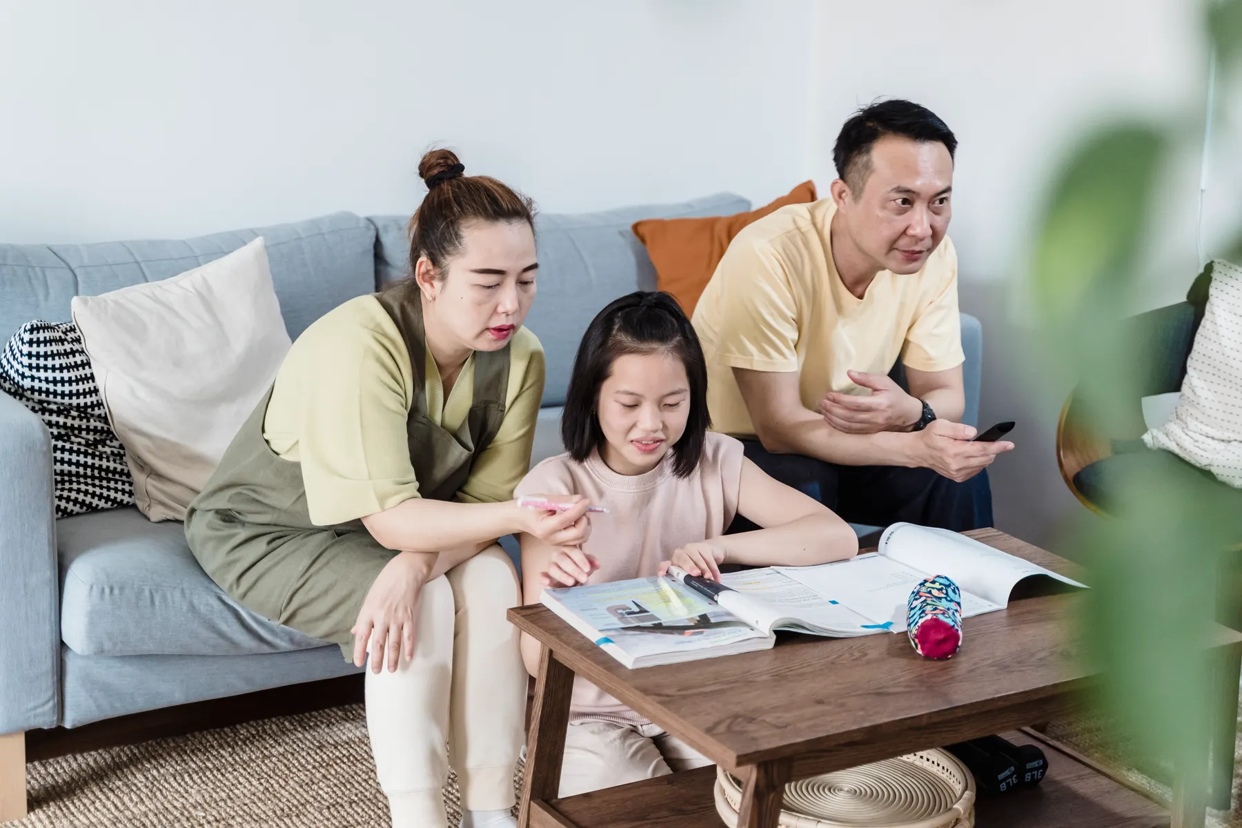 A parent and child reading a picture book together in a living room